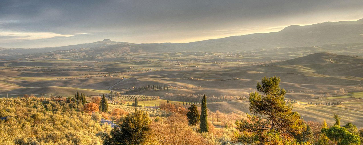 Paesaggio iconico della Val d'Orcia con colline sinuose e cipressi, Patrimonio UNESCO della Toscana